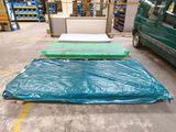 trois matelas posés à même le sol dans un entrepôt