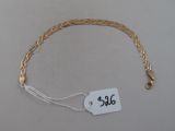 un bracelet en or muni d'une plaque, posé sur une table