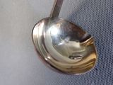 a silver spoon with a handle hanging on a wall