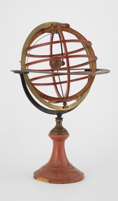 une ancienne maquette de cadran solaire posée sur un socle en bois