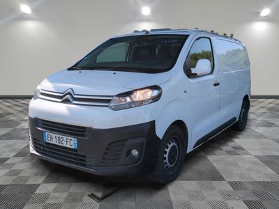 la camionnette blanche est garée dans une pièce au sol en damier