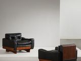 deux fauteuils en cuir noir et une table en bois dans une pièce blanche