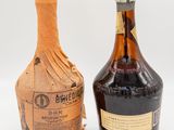 two bottles of alcohol sitting next to each other on a white surface