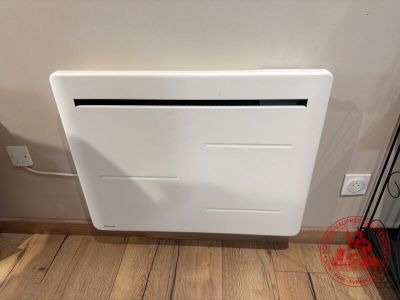 un radiateur mural blanc posé sur un parquet
