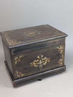 une boîte ancienne en bois dont le couvercle est orné d'un motif floral
