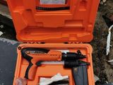 une mallette orange contenant des outils, posée sur un tas de bric-à-brac