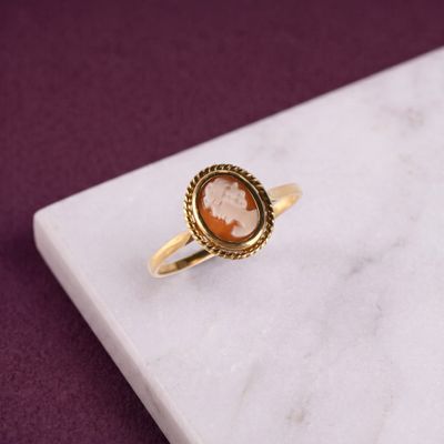 une image représentant une bague en or ornée d'un camée au centre