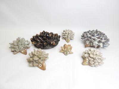 four small ceramic hedges are sitting next to each other on a white surface
