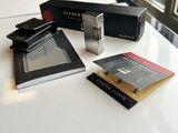 three books and a camera on a table next to a window