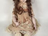 a doll that is sitting on the ground wearing a hat