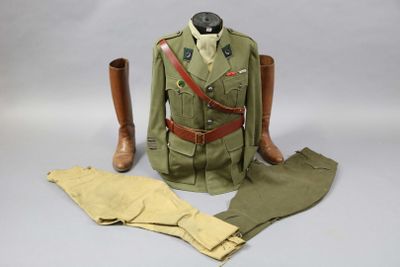 un uniforme et des bottes posés sur une surface blanche
