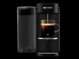 une cafetière noire à côté d'un verre d'eau sur un fond noir