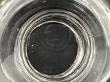 a close up of a clear glass with a black hole in it