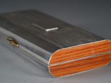 a silver box with a wooden lid sitting on a table