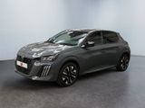Une voiture grise est garée dans une pièce aux murs blancs.