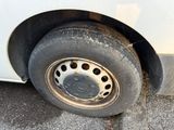 a dirty tire on the side of a white car