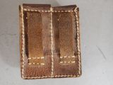brown leather wallet with two open compartments on a white surface