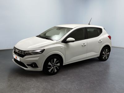La voiture blanche est garée dans une pièce au sol gris.
