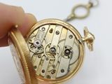 a person holding a pocket watch in their hand