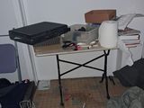 a table with a laptop on it in the corner of a room