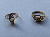deux bagues en or ornées de perles, posées sur une table