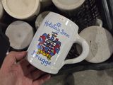 une personne tenant une tasse à café sur laquelle figure une image