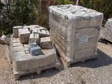 a pile of bricks sitting on the ground in front of a fence
