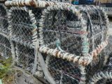 un tas de casiers à crabes posés par terre près d'un pont