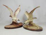 two figurines of birds that are sitting on top of each other