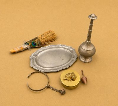 un plateau en argent, un bougeoir en argent et une paire de ciseaux posés sur une table