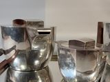 a silver tray with silver cups and spoons on it