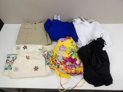 a white table with a bunch of clothing on it