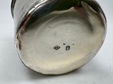 a close up of a silver vase on a white surface