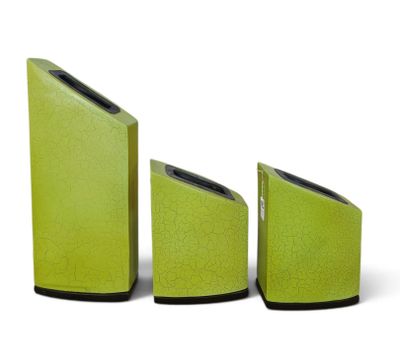 trois haut-parleurs verts placés les uns à côté des autres sur une surface blanche
