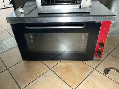 un four grille-pain posé sur un sol carrelé