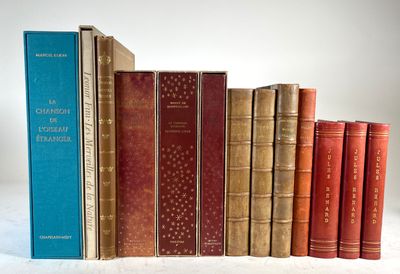 several old books are lined up on a white surface