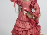 deux poupées représentant une femme en robe rouge avec un oiseau posé sur la main