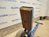a cart with a piece of wood on it in front of a wall