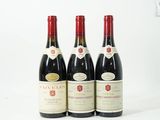 trois bouteilles de vin sont alignées sur une surface blanche