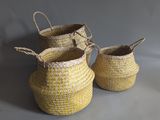 three yellow baskets with handles and handles on a grey background