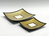 two black and gold bowls with square designs on them
