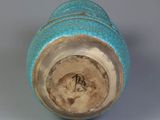 a close up of a blue vase on a white surface