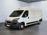La camionnette blanche est garée dans la grande salle du bâtiment.