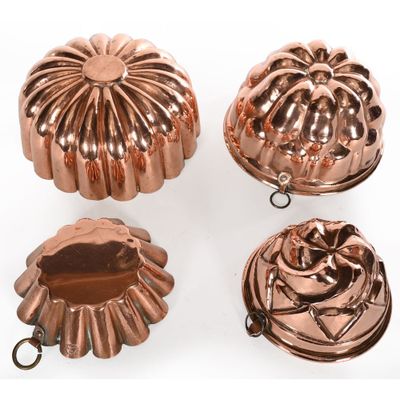 a set of four copper - plated cake pans