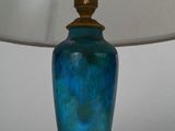 a blue lamp with a white shade on a table