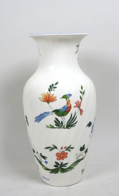 un vase blanc orné d'un oiseau et de fleurs