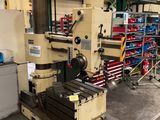 Une grande machine est posée dans un entrepôt, avec d'autres machines en arrière-plan.