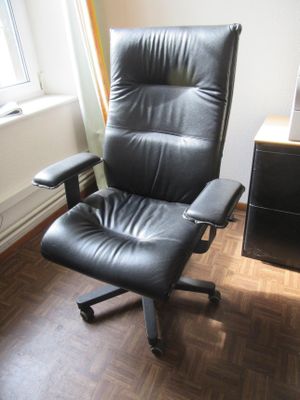 une chaise de bureau noire placée devant une fenêtre