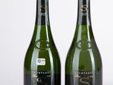 deux bouteilles de vin posées l'une à côté de l'autre sur une table