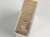 a gold bar that is sitting on a white surface